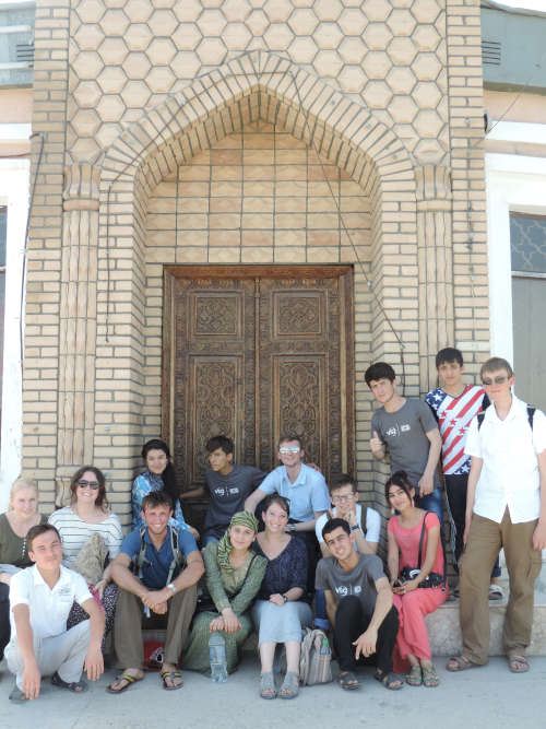 Photo of our staff and volunteers sitted outside of an old building